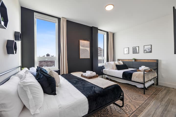 Svijetla spavaća soba s bračnim krevetom, crnim zidom, velikim prozorima i mekanim jastucima. Naš smještaj za odmor spaja moderan dizajn s udobnim utočištem – obiteljski smještaj na Airbnbu savršen je za okupljanja i mirne noći.