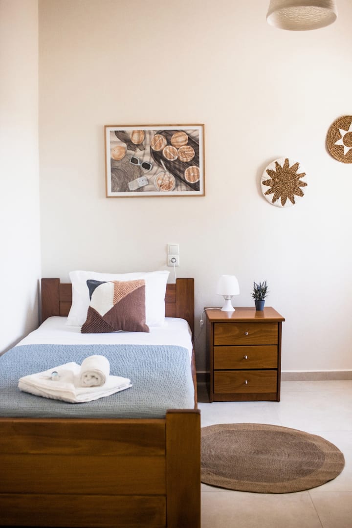  Une chambre simple confortable avec une décoration de bon goût, des textures naturelles et une palette de couleurs chaudes.
