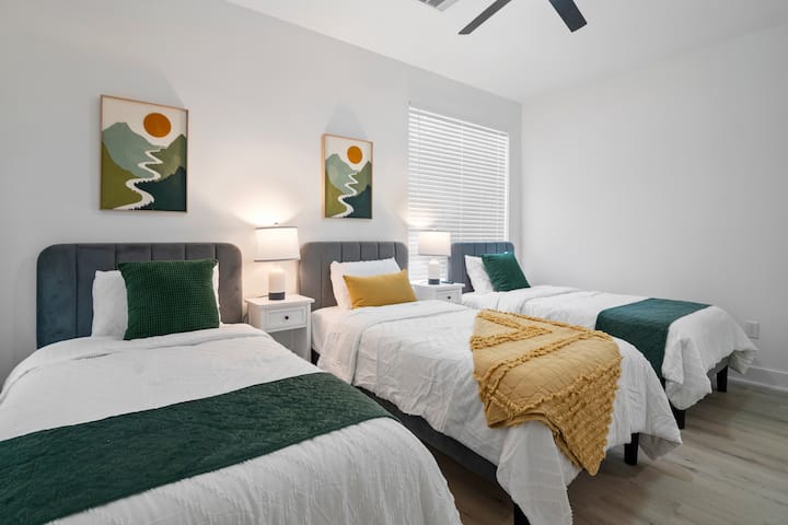 Accogliente camera da letto con tre letti singoli, ideale per bambini, amici o soggiorni di gruppo.