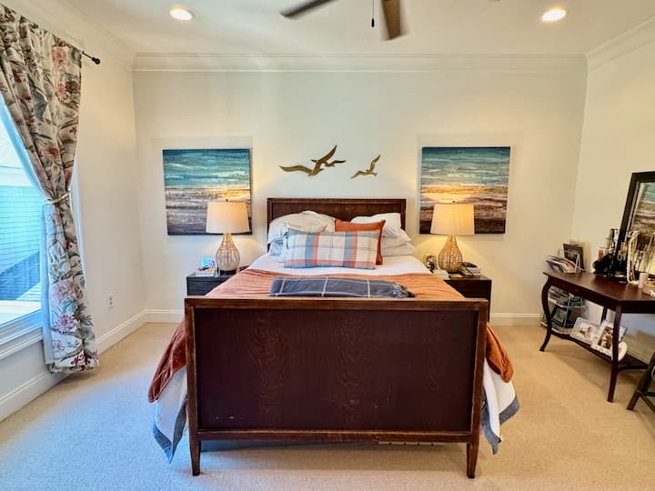 ห้องนอนมาสเตอร์สไตล์ดีไซเนอร์พร้อมเตียงควีนไซส์จะกลายเป็นที่พักพิงริมทะเลที่คุณสามารถได้ยินเสียงจากสนามกีฬาได้จริงๆ เมื่อเปิดหน้าต่าง ผ่อนคลาย ยกเท้าขึ้นและฟังเสียงเกมหรือเสียงลูกๆ เล่นอยู่บนดาดฟ้า รูปถ่ายในเอเธนส์โดย Nelson & April