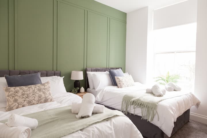 Tranquil double bedroom with large windows and soft natural light.
Features two comfy double beds, plush bedding, and modern décor.
Perfect for restful nights after a day of exploring or working.