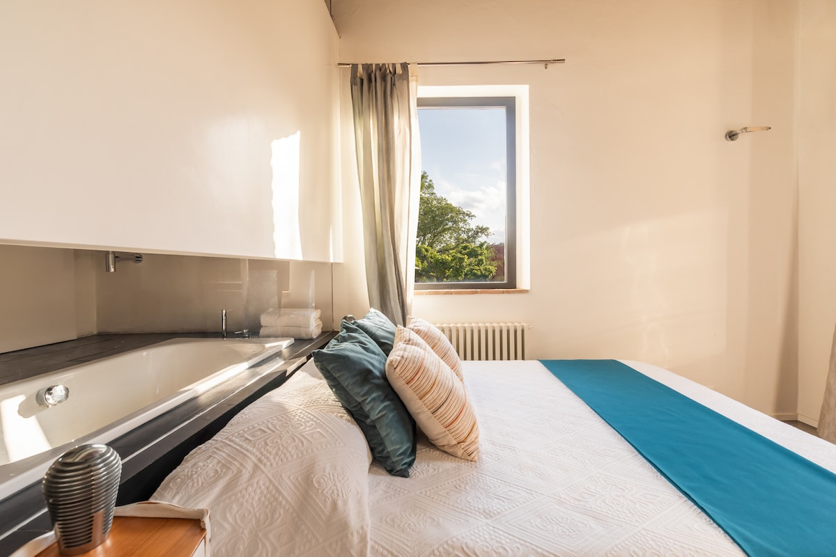 Ensuite bedroom with tub, air conditioning, closet