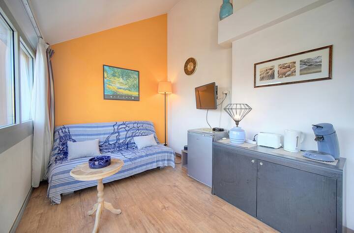 Le salon offre un coin cosy avec une cafetière pratique pour une pause-café. Imprégnez-vous de la lumière naturelle et du style moderne tout en savourant un instant de détente sur le canapé confortable.