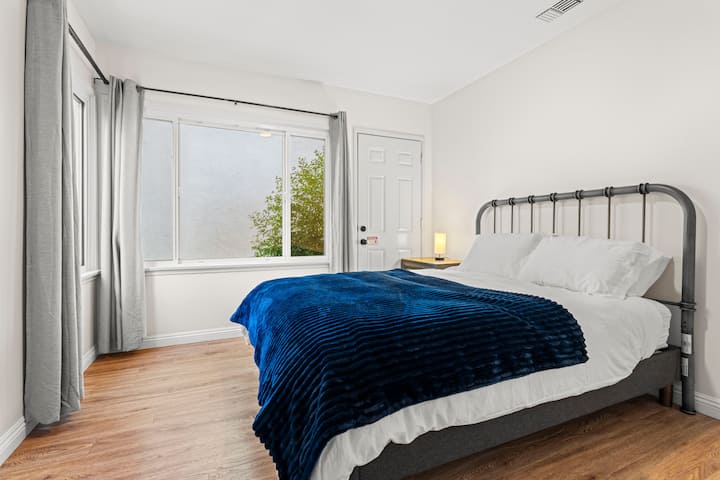 Chumba cha kulala chenye mwangaza na kitanda chenye starehe, mashuka laini na mwanga mwingi wa asili, unaofaa kwa usiku wa kupumzika.