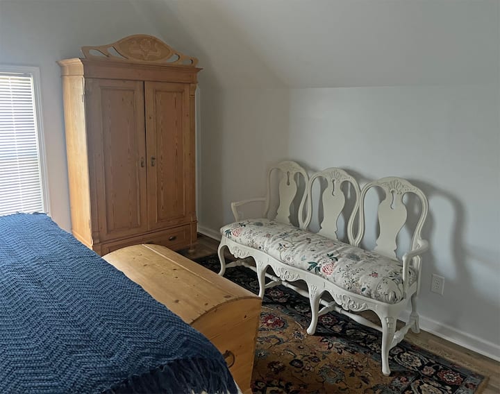 Spálňa na poschodí s manželskou posteľou veľkosti king-size a starožitnou borovicovou skriňou v secesijskom štýle. Dánska gustaviánska pohovka.