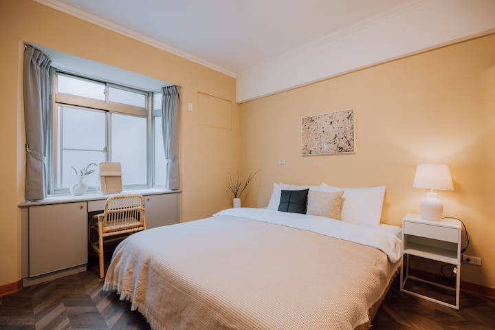 Cómodo espacio en el dormitorio principal con un área de trabajo y una decoración tamaño king (180 cm) solo como referencia: almohada, almohada pequeña (solo dos almohadas para una cama), manta decorativa, maceta