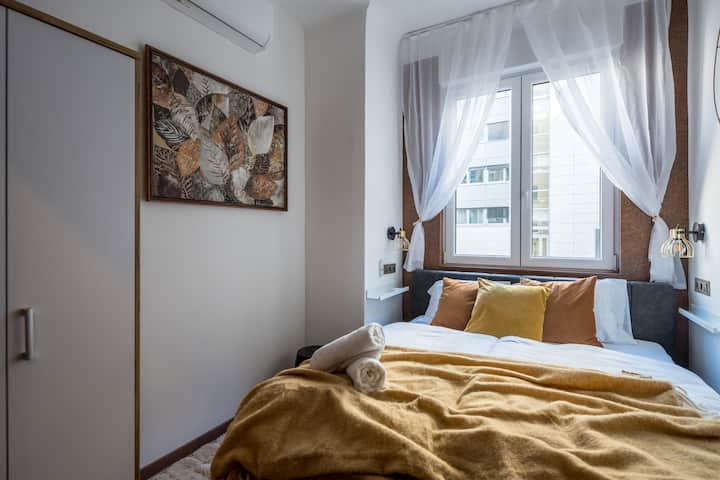 Une chambre sur le thème de l'automne avec un lit confortable de 160 x 200 cm, une armoire spacieuse et des volets motorisés pour un confort ultime. La chambre est climatisée, et de grandes fenêtres remplissent l'espace de lumière naturelle, créant une atmosphère chaleureuse et accueillante.