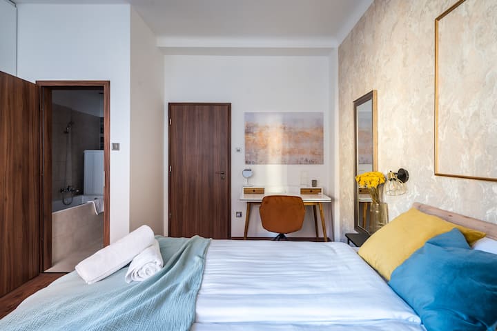 Chambre estivale avec lit 180x160cm, salle de bain privée avec volets motorisés, climatisation et armoire intégrée. Télévision par câble et Netflix, espace de travail polyvalent pour le travail ou le maquillage, et patio privé spacieux.