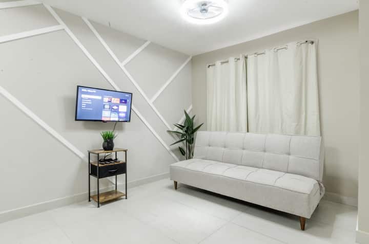 Dhomë ndenjjeje me ndriçim të shkëlqyer, televizor inteligjent dhe divan-krevat, e përkryer për t’u çlodhur dhe për të shijuar qëndrimin tënd.