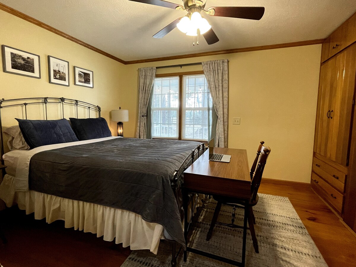 Slaapkamer 1:  queensize bed. Werkruimte. Aangepaste inbouw cederhouten kasten.