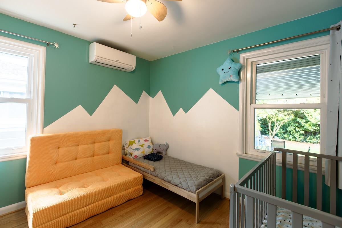 Cette chambre est équipée d'un lit pour bébé, d'un lit pour bébé et d'un matelas au sol à trois volets (grand format).