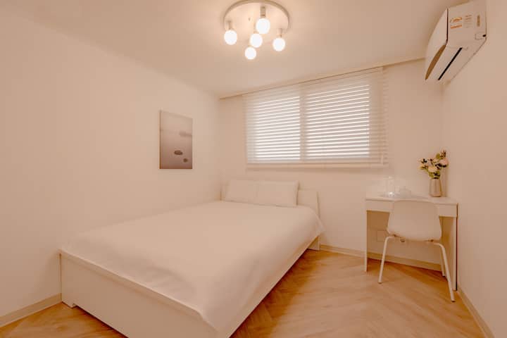 “심플하고 아늑한 감성의 작은 침실입니다. 혼자 또는 커플이 머물기 좋은 구성으로, 창가에서 따뜻한 햇살과 함께 여유로운 휴식을 즐기실 수 있어요.”