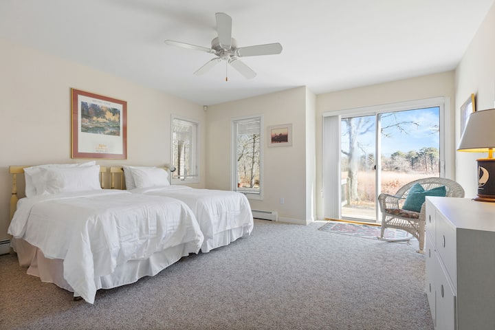 Privlačna spavaća soba s dva odvojena kreveta, kupaonicom i klizačima koji se otvaraju prema terasi koja omogućuje jednostavan pristup otvorenom. 