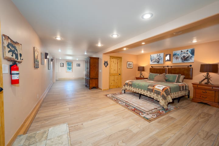 Downstairs, there are two sleeping areas in an open, finished basement.   This, the larger of the two areas features a king bed.