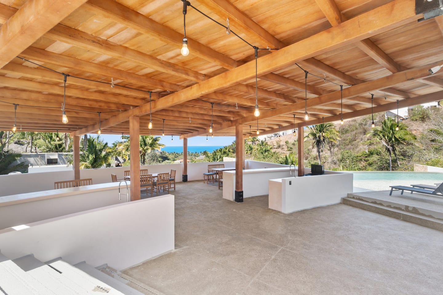 Enjoy the stunning views from the rooftop outdoor entertaining space. This inviting area is perfect for daytime gatherings, with comfortable seating and a beautiful backdrop of the ocean and lush surroundings.