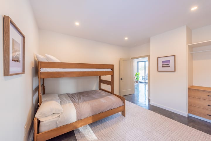 Adjacent to the kitchen is a versatile space that can serve as an office or a bedroom, featuring a custom queen bottom and twin top bunk bed.