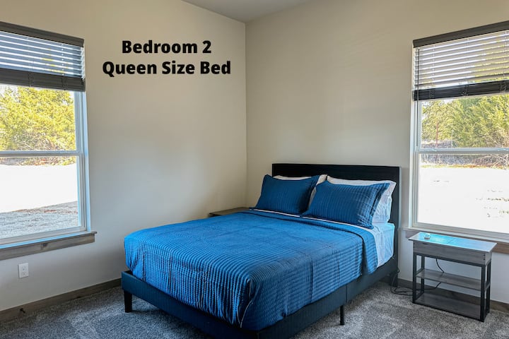 The bedroom in the far back to the left features a queen size bed, ceiling fan, and some books. Also has a closet for you to hang your clothes.
