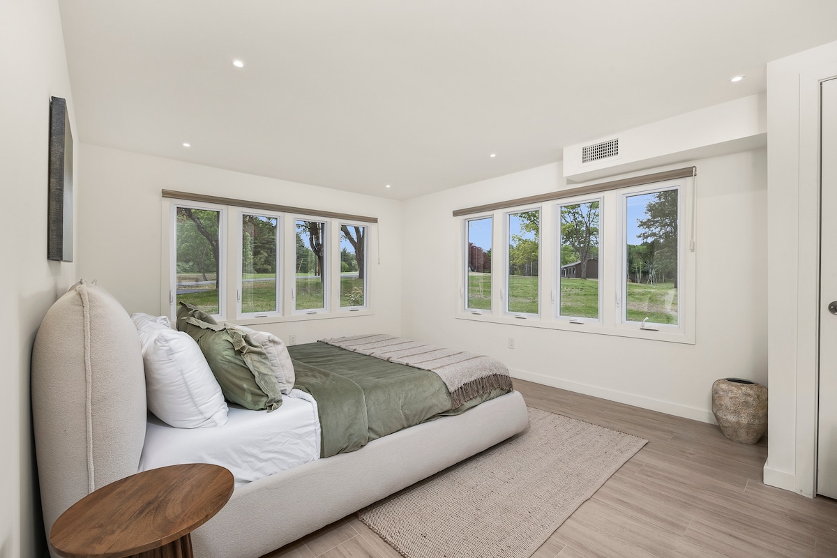 חדר שינה עם מיטת קווין סייז ממוקם ליד הסלון.