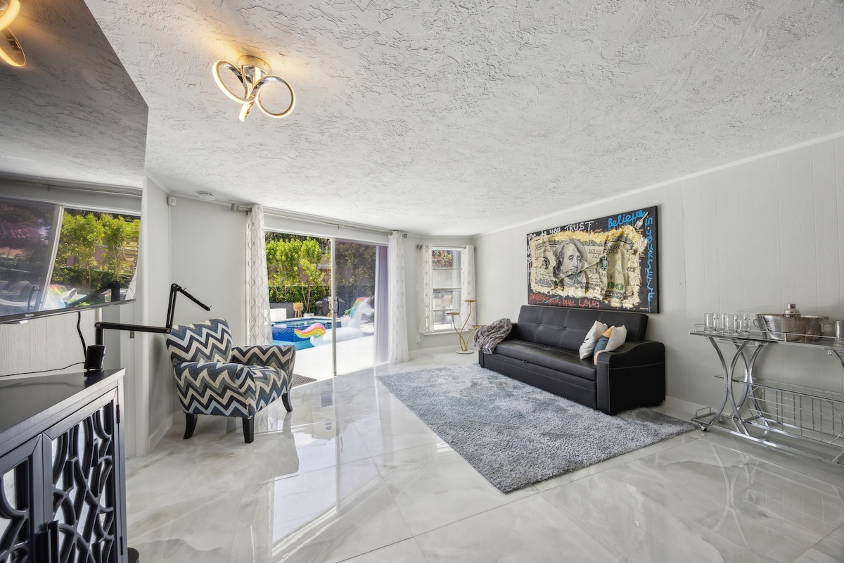 Elegant Dining Overlooking Pool
Contemporary dining space with a circular table, plush chairs, designer lighting, and beautiful sightlines to the pool patio—ideal for family meals or cocktails indoors.