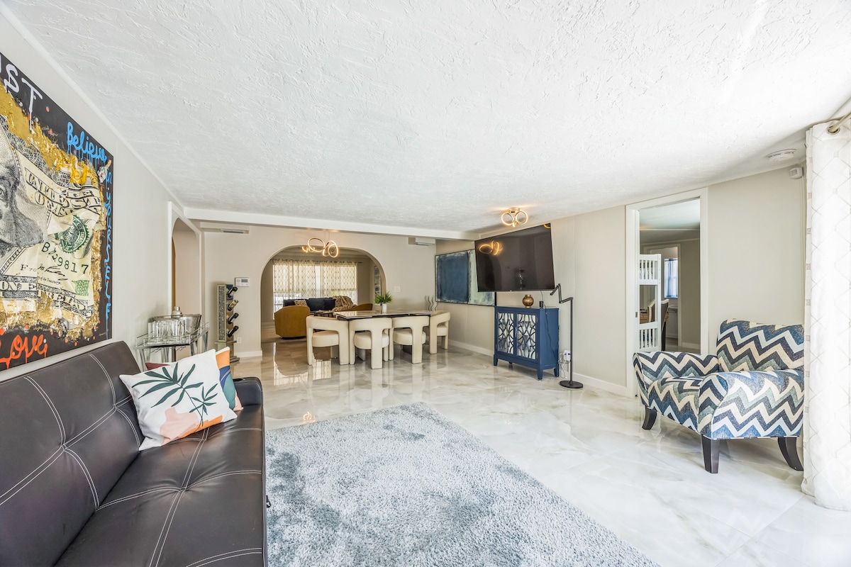 Elegant dining space with marble-style table and ultra-comfy chairs. Open layout flows beautifully into the living room with direct views of the pool and patio.