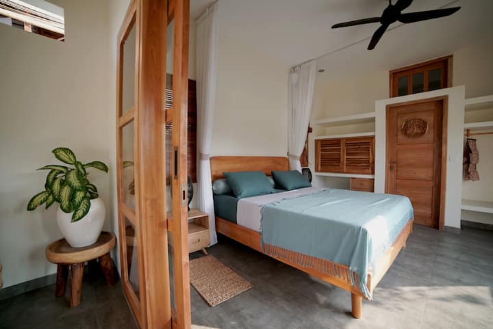 Спална соба со врата кон сопствена бања.