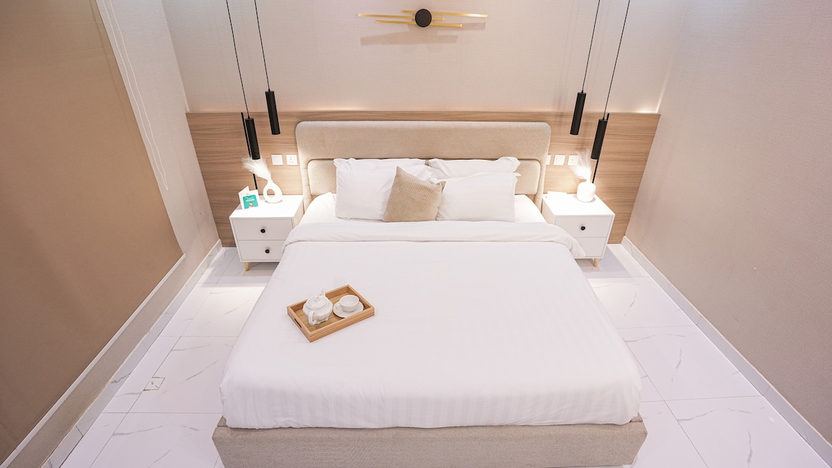 זווית חלופית של חדר השינה, המדגישה את הפריסה המאוזנת ואת הנוחות של שידת הלילה.
