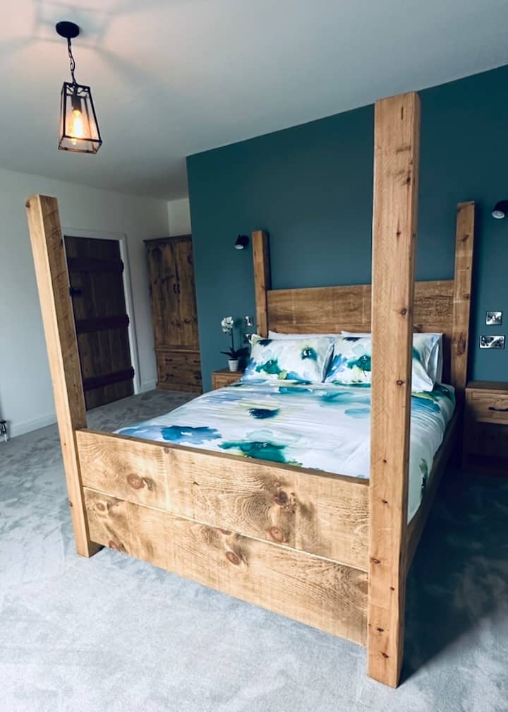 Bedroom 1 at Ty Mawr has a large Kingsize Four Poster Bed.  This bedroom has wooden shutters an original cast iron Fireplace and and En-suite Bathroom.

There is also a Double Wardrobe, dressing table, two Bedside cabinets and a Smart TV.