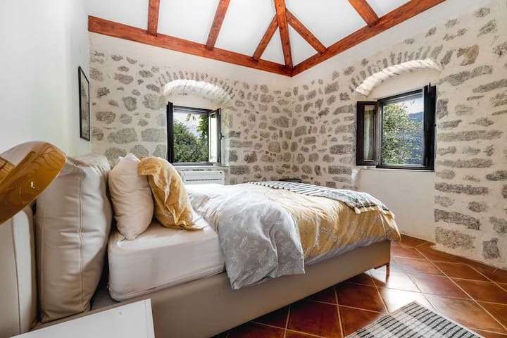 Slaapkamer met nieuw queensize bed, nieuw matras, designer linnengoed en airconditioning.  Ramen met prachtig uitzicht op de baai van Kotor.