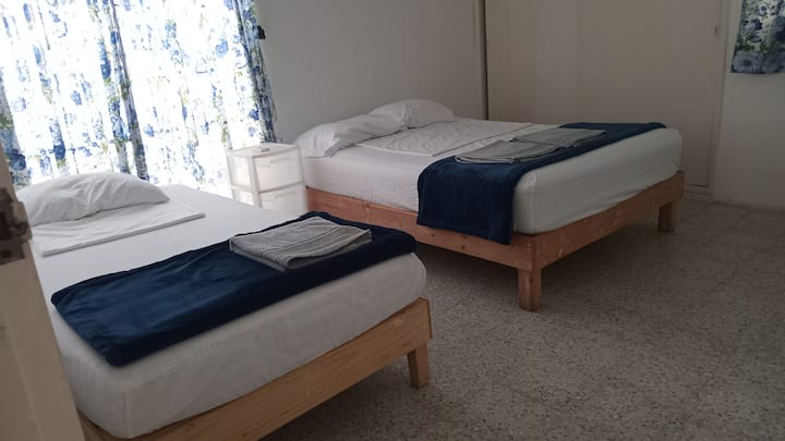 Chumba hiki cha watu 3 kiko kwenye ghorofa ya chini pamoja na chumba cha kulala cha 1. Na ni mojawapo ya vyumba vinavyopendelewa na wazee wetu kwa faragha, utulivu na starehe yake.

Pia ina hali ya hewa.