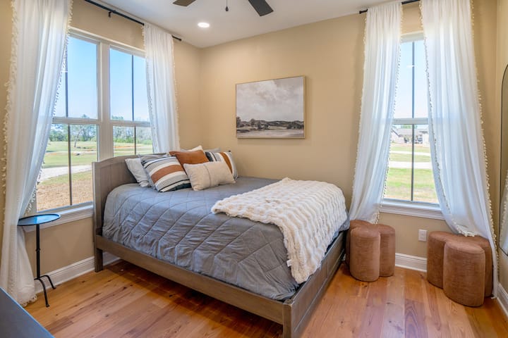 This cozy and private primary bedroom features a generous walk-in closet, ceiling fan, and a brand-new 55" mounted flat-screen TV (not yet pictured). A comfortable retreat to unwind and recharge.