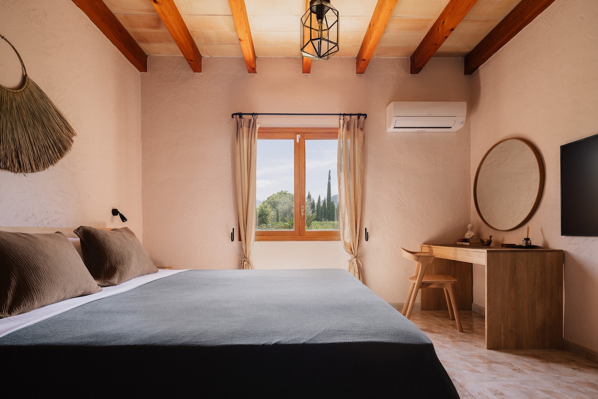 Ნათელი, ფართო საძინებელი მუხის კომფორტული საწოლით, ჩაშენებული კარადებით, ტელევიზორითა და სამუშაო მაგიდით და მთების განსაცვიფრებელი ხედებით