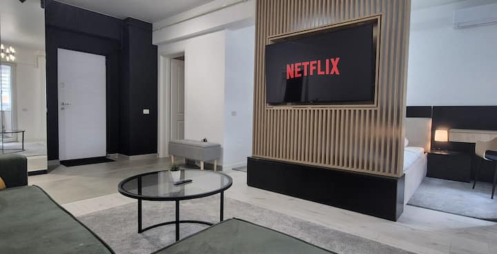 Entra en una elegante y moderna sala de estar con un lujoso sofá cama extensible, un televisor inteligente de 55pulgadas en un panel giratorio para ver la cama o el salón, wifi de alta velocidad y acabados completamente nuevos. Disfruta de un espacio impecable con comodidad elegante en cada detalle.
