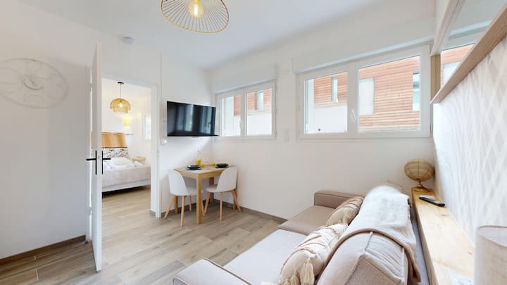 تجتمع جميع وسائل الراحة معًا في غرفة معيشة مع أريكة ومنطقة لتناول الطعام ومطبخ وتلفزيون