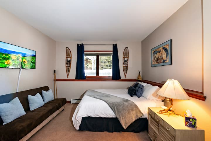 Cette chambre polyvalente est parfaite pour les groupes de 4 personnes, avec un lit queen size confortable, un lit futon, une télévision connectée et des rideaux qui obscurcissent la pièce. Le thème autochtone avec une exposition de raquettes vintage ajoute une touche unique à votre séjour. Réservez votre escapade dès aujourd'hui ! ️✨