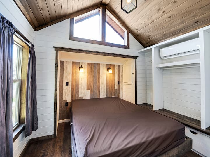 ห้องนอนควีนไซส์พร้อมที่เก็บของใต้เตียงสำหรับใส่กระเป๋าเดินทาง ราวแขวนตู้เสื้อผ้าตะขอและลิ้นชักดึงออกด้านล่าง