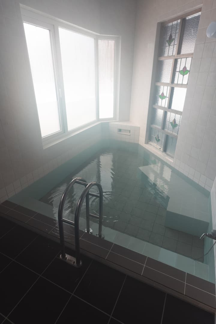 女性用の湯船は大人3人が足を伸ばして浸かれる広さ。ガラスは透明で森の木々を眺めながら入れます。