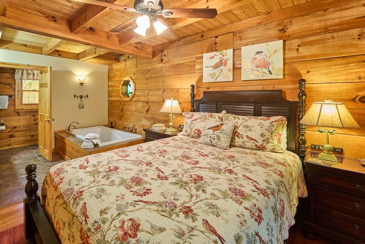 El dormitorio de la planta principal, completo con un baño privado, sirve como un acogedor refugio para parejas por sí solo, con una cómoda cama tamaño queen y una bañera de hidromasaje privada para lo último en relajación.