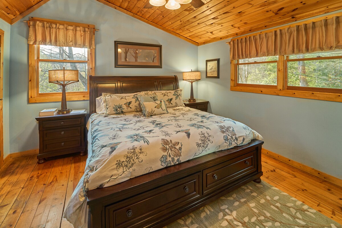 חדר השינה בקומה העליונה שוכן בלופט פרטי וסגור חלקית, עם מיטת קינג סייז מפוארת וחדר רחצה צמוד נוח.