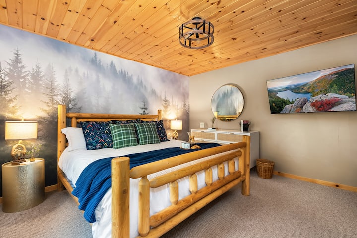 Dormitorio principal con una cama tamaño king mejorada con un cautivador mural en la pared del bosque