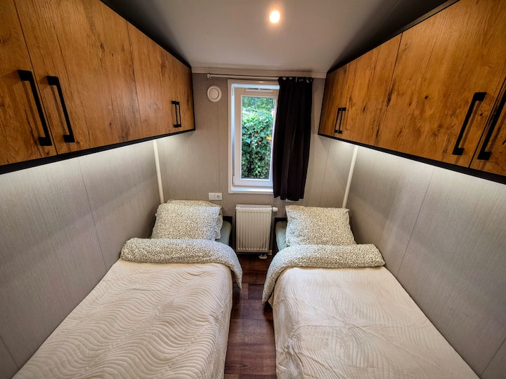 Twee losse bedden in een knusse, lichte slaapkamer. Ideaal voor kinderen of vrienden die samen genieten van een ontspannen vakantie in Mariënberg, Overijssel.