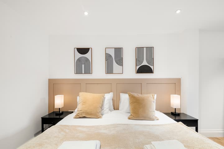 Relaksohu në stil – një dhomë gjumi me hapësirë të bollshme me një krevat luksoz të madhësisë king dhe një vend i përkryer për t 'u çlodhur me shfaqjet e tua të preferuara në televizor.