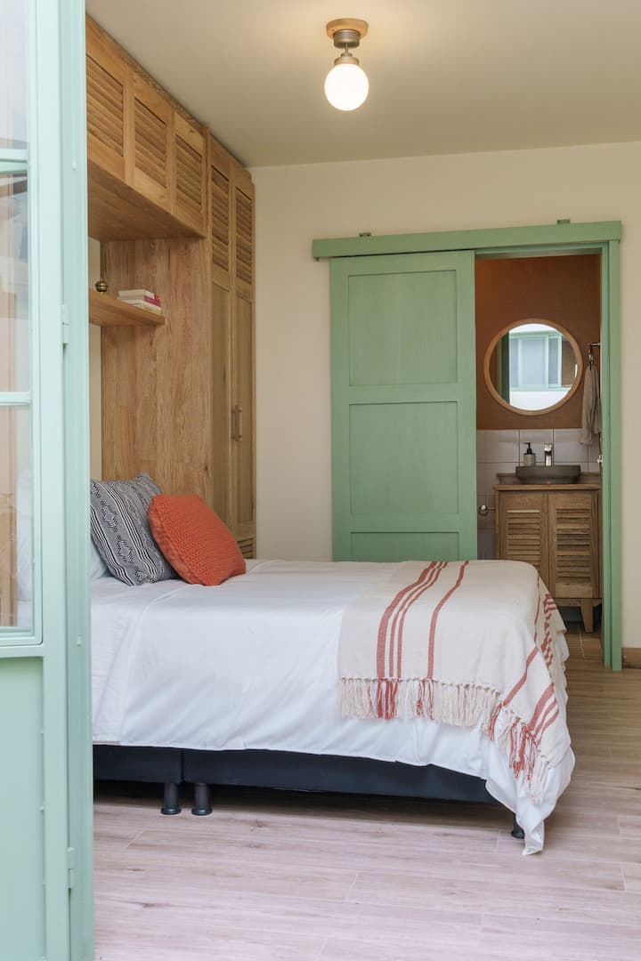 Habitación secundaria conectada al jardín interno, brindando una sensación única de amplitud y abundante luz natural. Un espacio acogedor y armonioso para un descanso placentero.