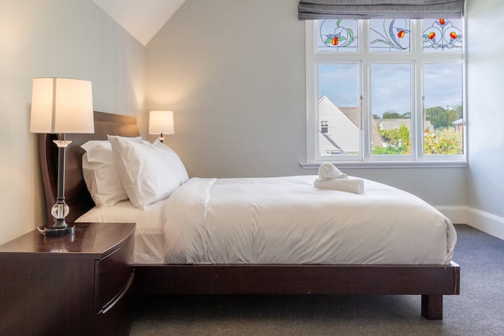 Udobna i minimalistička spavaća soba s hrskavim bijelim plahtama i mekom dekom.