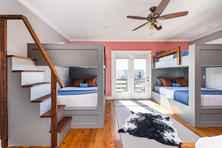 Dhomë me krevate marinari | 8 persona | Kati i 2-të | Banjë e bashkangjitur
Dy krevate marinarë të ndërtuar me porosi me hyrje në shkallë, ndriçim të rehatshëm dhe ngjyra të guximshme, të përsosura për grupe të mëdha ose të qeshura natën vonë.