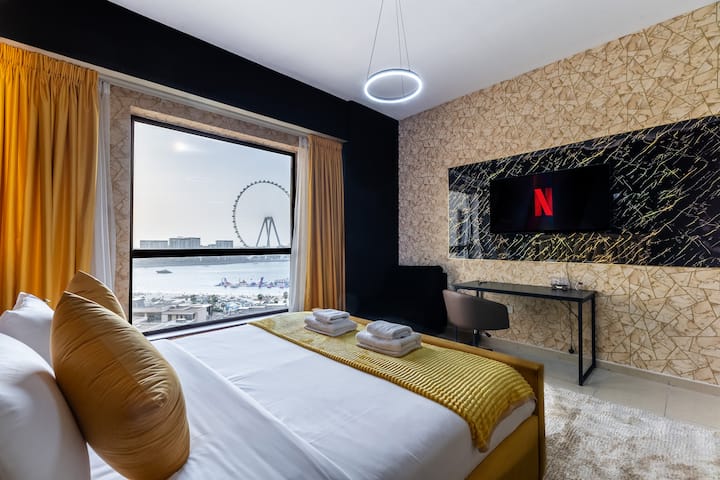 Un lujoso dormitorio con un diseño moderno, con una cama grande vestida con sábanas blancas frescas, acentuada por almohadas amarillas de mostaza y un acogedor tiro de punto. 