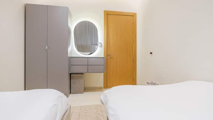 Get ready in style with a bright vanity station, accented by modern lighting and situated next to soft, twin bedding for restful nights.

