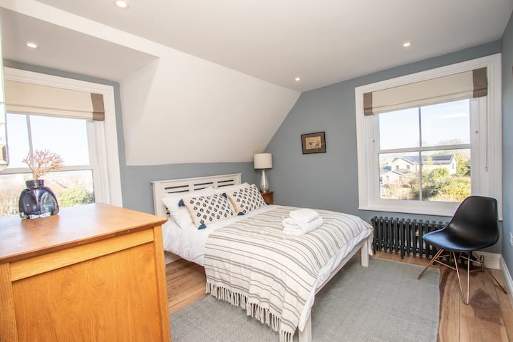 Opustite se u ovoj mirnoj spavaćoj sobi obojanoj u svijetloplavu boju s udobnim bračnim krevetom i madracem s oprugama. Mnogo prostora za odlaganje odjeće i crne rolete za zamračenje upotpunjuju prostor. Probudite se i uživajte u predivnom pogledu na epske izlaze sunca na horizontu. 