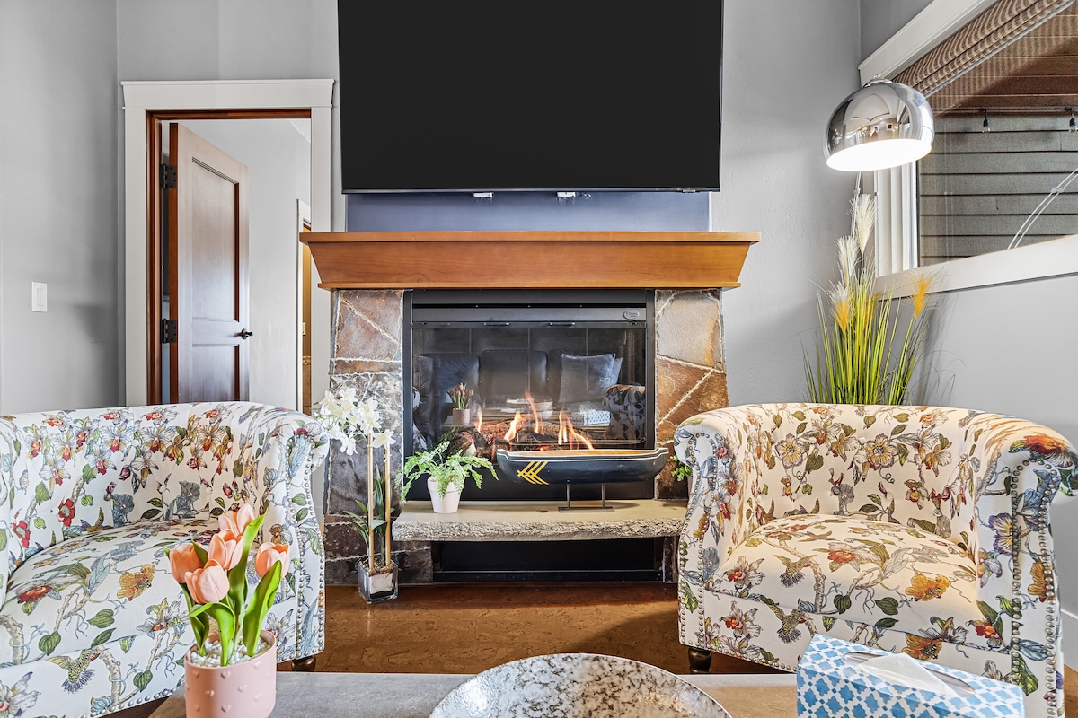 Štýlová obývačka s 3-metrovými stropmi, útulným elektrickým krbom, inteligentnou televíziou a elegantnou výzdobou – ideálna na oddych po dni strávenom v horách.