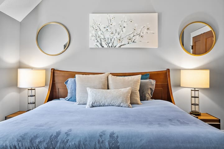 Dormitorio principal con cama tamaño king, chimenea eléctrica y TV inteligente curva.