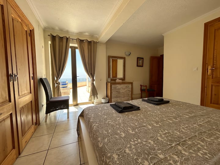 Chambre principale avec salle de bains privative et accès à la terrasse